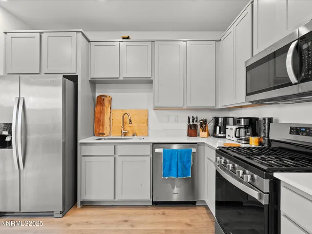 a kitchen with stainless steel appliances granite countertop a refrigerator a stove and a sink