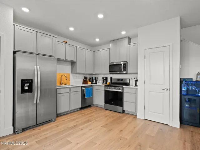 a kitchen with stainless steel appliances granite countertop a refrigerator and a stove top oven