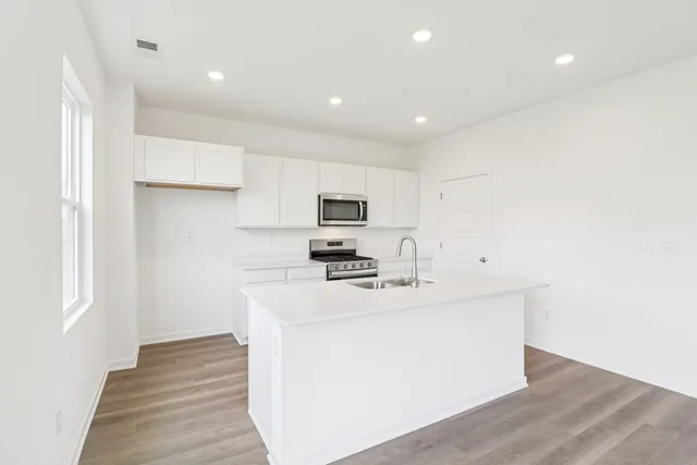 a kitchen with a sink cabinets and wooden floor