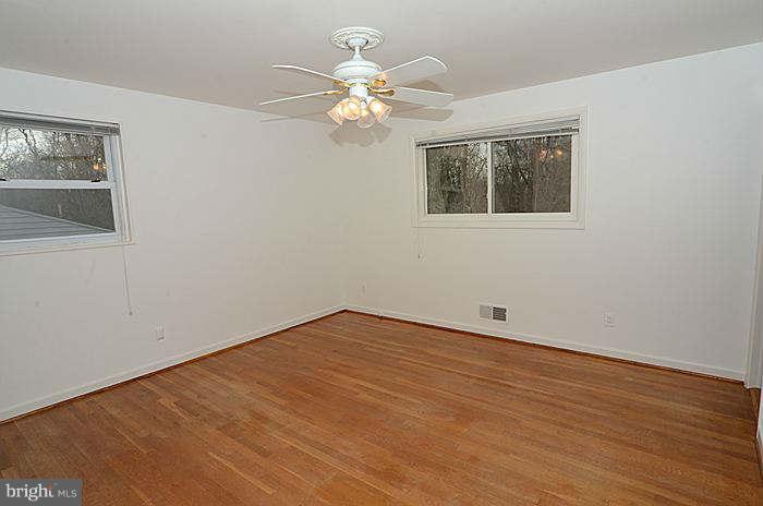 12514 Littleton Street Silver Spring, MD 20906 - Photo 8 of 29 a view of an empty room with wooden floor and a chandelier fan