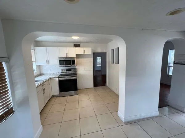 a kitchen with granite countertop a refrigerator and a stove top oven