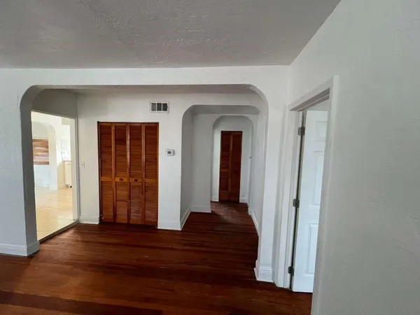 a view of a hallway with wooden floor and stairs