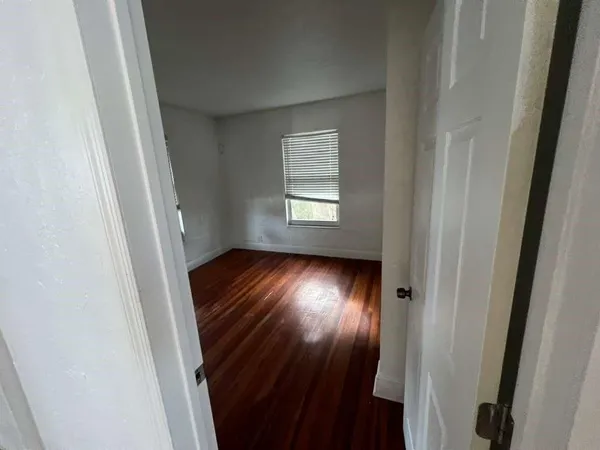 a view of empty room with wooden floor