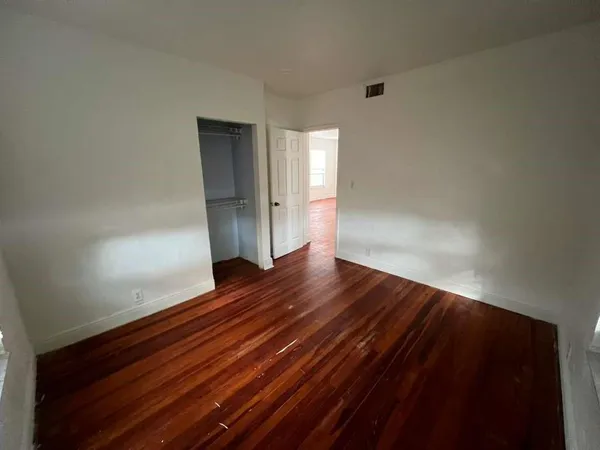 a view of empty room with wooden floor