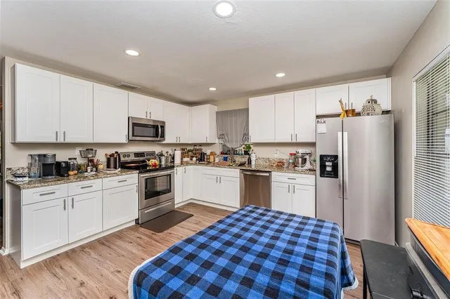 a kitchen with granite countertop appliances a sink and cabinets