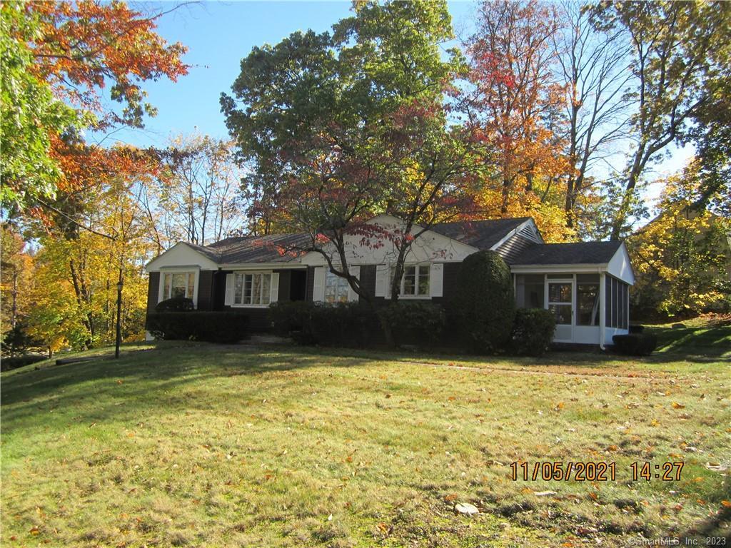 a front view of a house with yard and trees