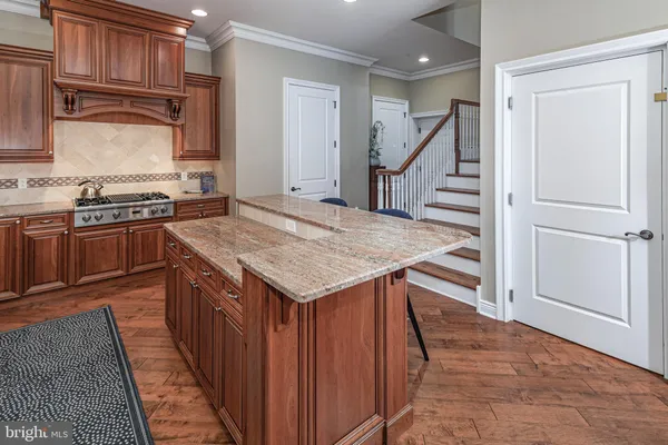 a kitchen with granite countertop a stove and a kitchen island