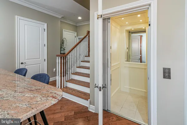 a view of a hallway with wooden floor and staircase