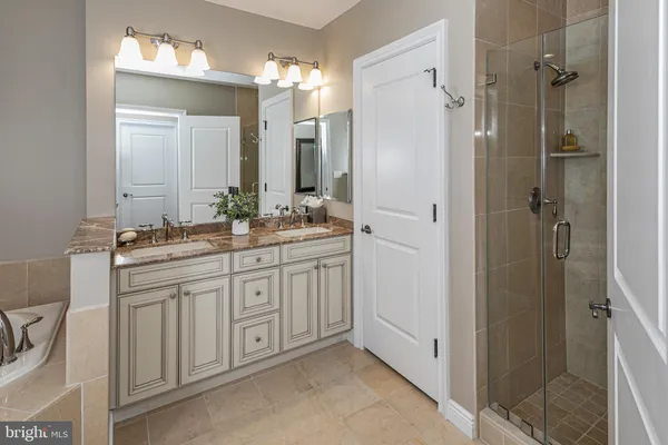 a bathroom with a double vanity sink mirror and shower