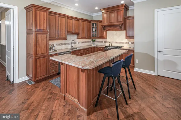 a kitchen with kitchen island a stove a refrigerator and a sink with wooden cabinets