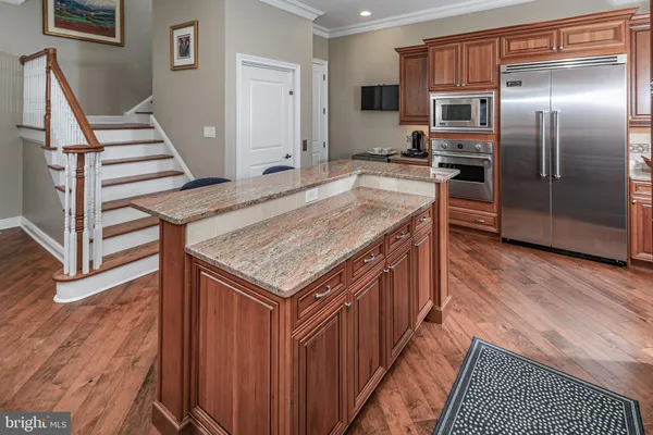a kitchen with a refrigerator a sink and wooden floor