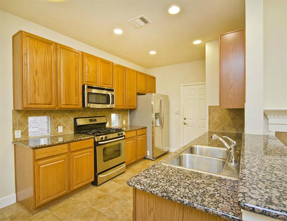14812 Avery Ranch Boulevard, Unit 16 Austin, TX 78717 - Photo 12 of 32 a kitchen with stainless steel appliances granite countertop a sink stove refrigerator and cabinets