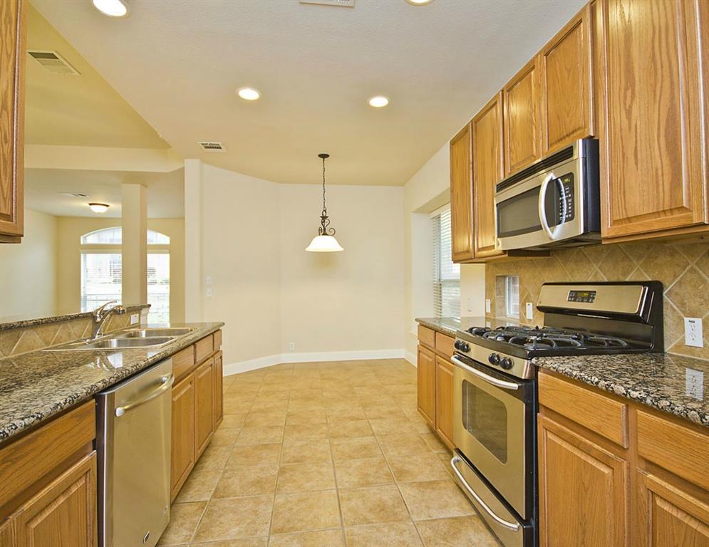 14812 Avery Ranch Boulevard, Unit 16 Austin, TX 78717 - Photo 13 of 32 a kitchen with stainless steel appliances granite countertop a stove a sink and a microwave