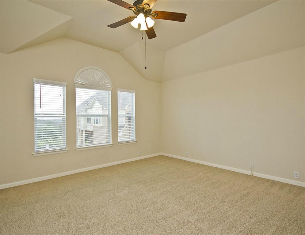 14812 Avery Ranch Boulevard, Unit 16 Austin, TX 78717 - Photo 18 of 32 an empty room with a chandelier fan and windows
