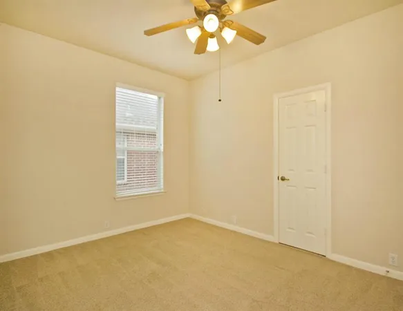 an empty room with a chandelier fan and closet area
