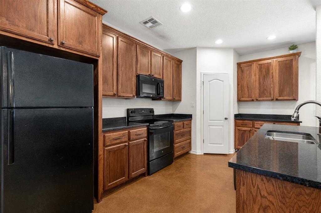3309 South 3rd Street Waco, TX 76706 - Photo 9 of 31 a kitchen with a refrigerator a microwave a sink and cabinets