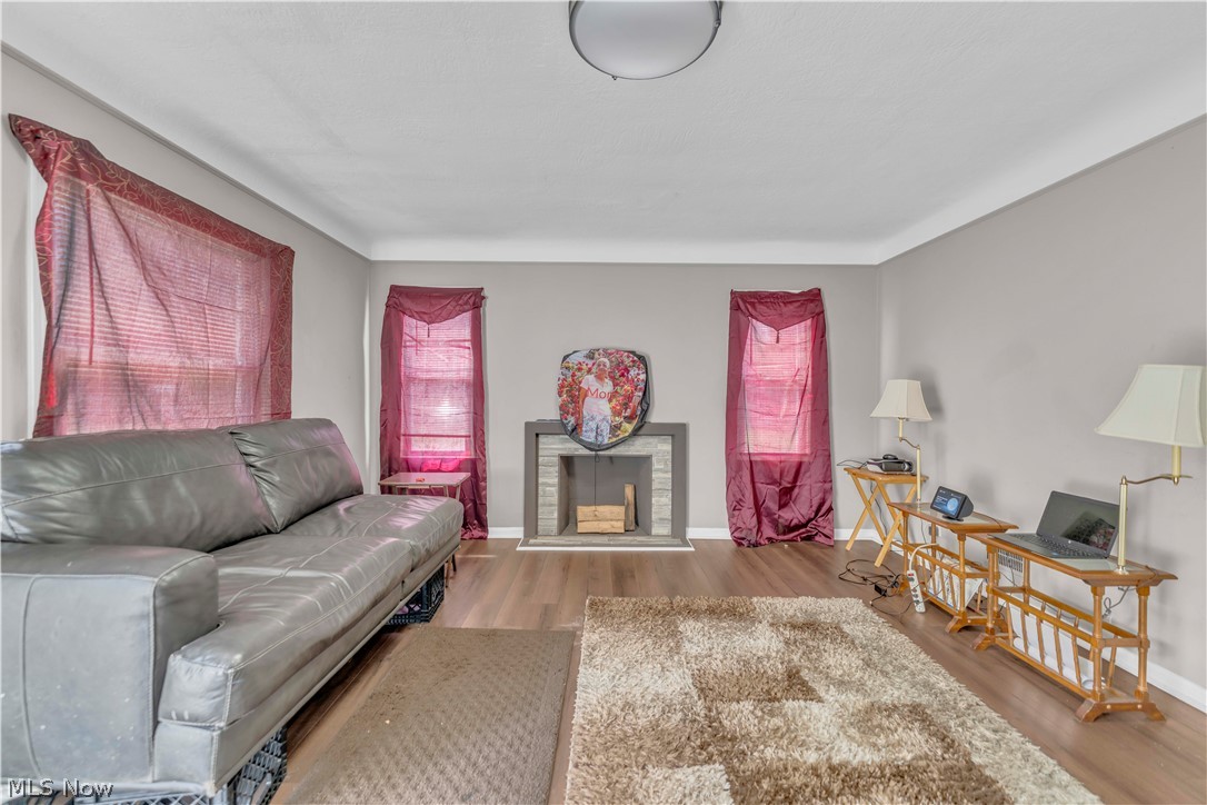 3731 Lowell Road Cleveland Heights, OH 44121 - Photo 5 of 29 Wood-finish flooring throughout, light gray wall paint, and a decorative fireplace with a gray tile surround