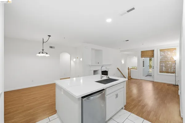 a view of a kitchen island a sink dishwasher with wooden floor