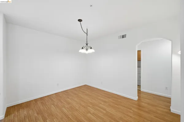 a view of a room with wooden floor and ceiling fan