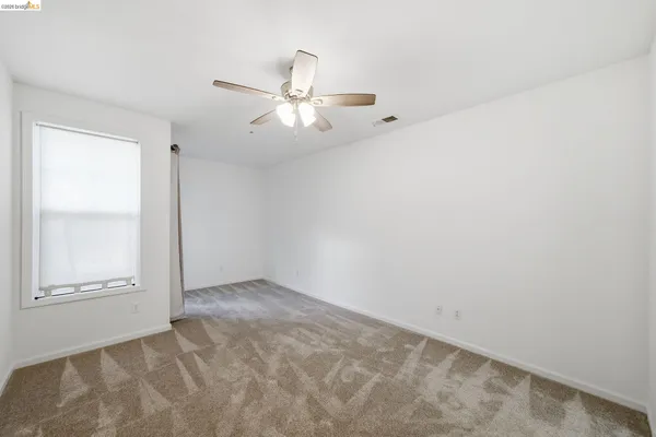 an empty room with closet and windows