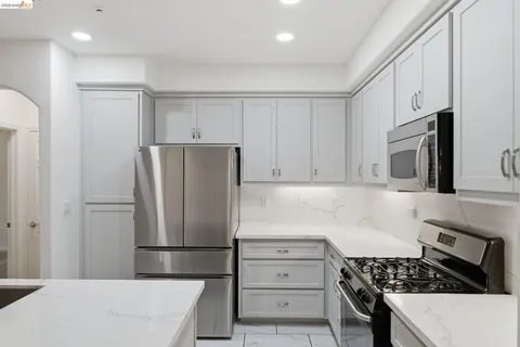 a kitchen with refrigerator a stove a microwave and cabinets