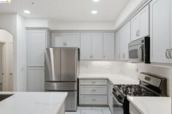 a kitchen with refrigerator a stove a microwave and cabinets