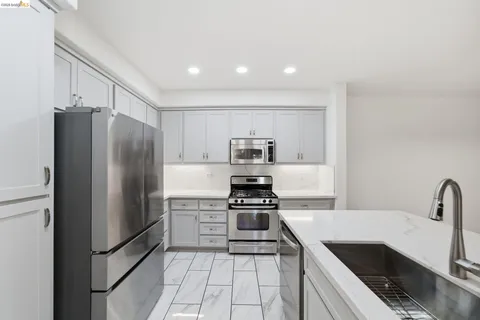 a kitchen with stainless steel appliances a refrigerator sink and stove