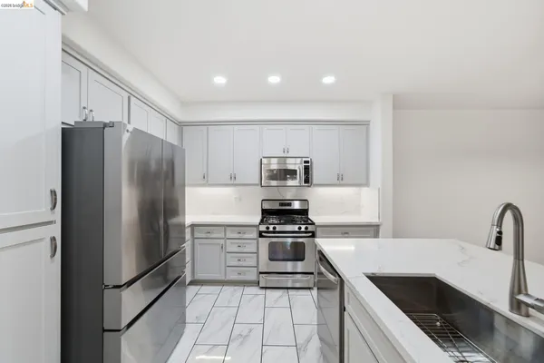 a kitchen with stainless steel appliances a refrigerator sink and stove