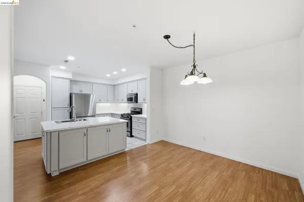 a kitchen with a sink stainless steel appliances and white cabinets