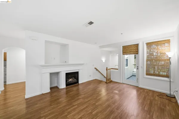 a view of empty room with wooden floor and fireplace