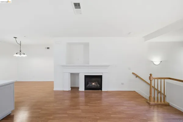 a view of empty room with wooden floor and fireplace