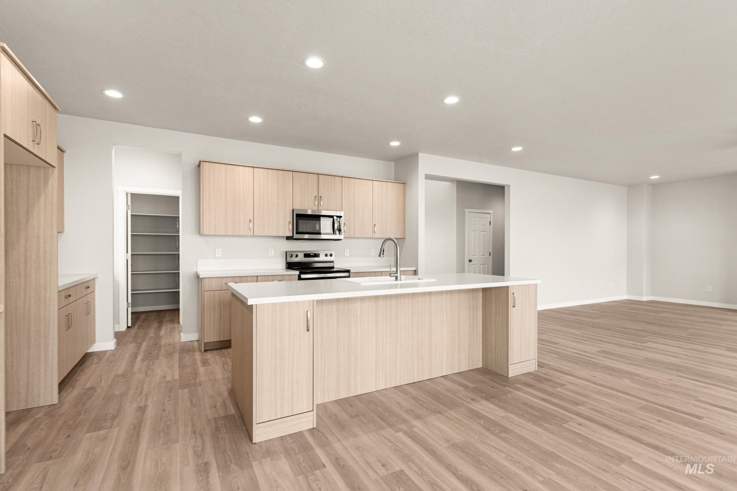 13688 Redway Court Caldwell, ID 83607 - Photo 24 of 26 Kitchen featuring an island with sink, recessed lighting, light wood-type flooring, stainless steel appliances, and open floor plan