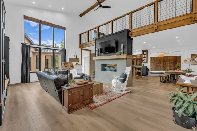 1766 West Tollgate Cyn Road Coalville, UT 84017 - Photo 4 of 59 Spacious living area featuring high ceilings, wood-finish flooring, a contemporary fireplace with a concrete surround, large windows, and an exposed wood beam