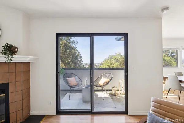 a living room with furniture a potted plant and a large window