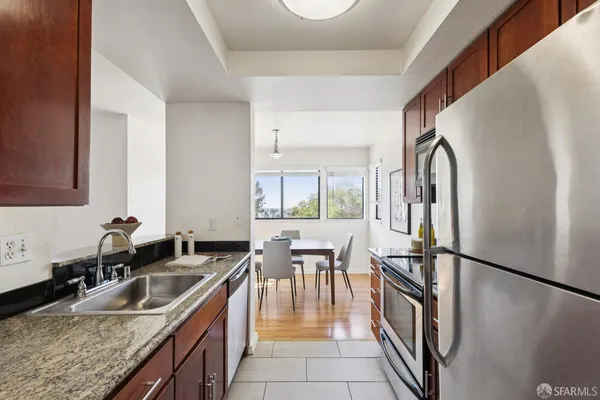 a kitchen with granite countertop a sink a counter top space and stainless steel appliances