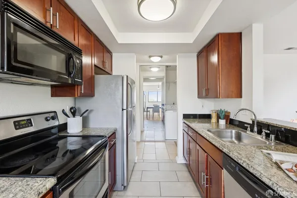 a kitchen with stainless steel appliances granite countertop a sink stove and refrigerator