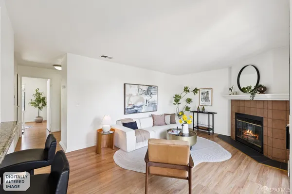 a living room with furniture a fireplace and potted plants