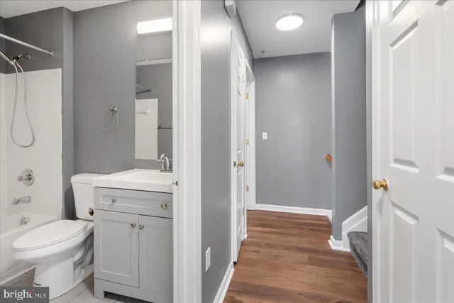 a bathroom with a granite countertop sink a toilet and shower