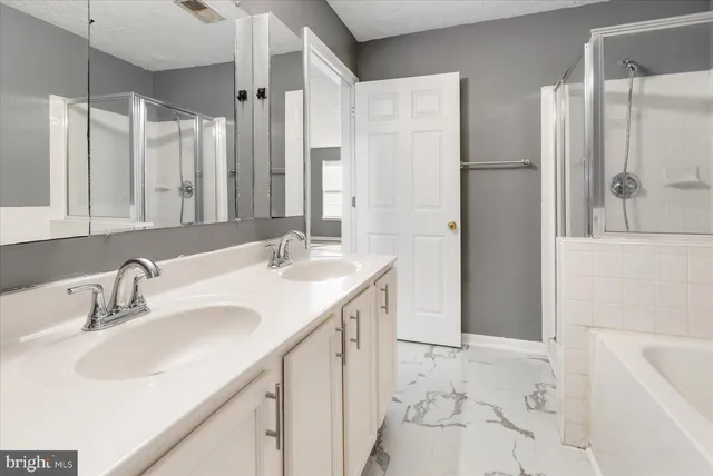 a bathroom with a double vanity sink a mirror and a bathtub