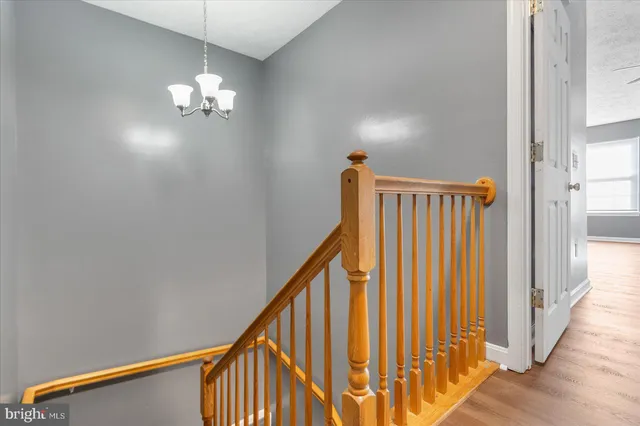 a view of a hallway with wooden floor and staircase