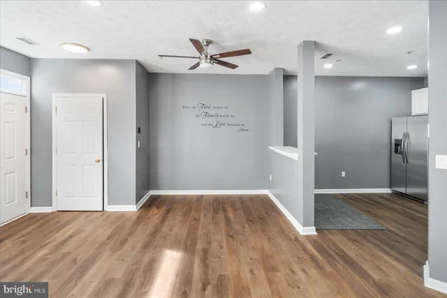 a view of a big room with wooden floor and a ceiling fan