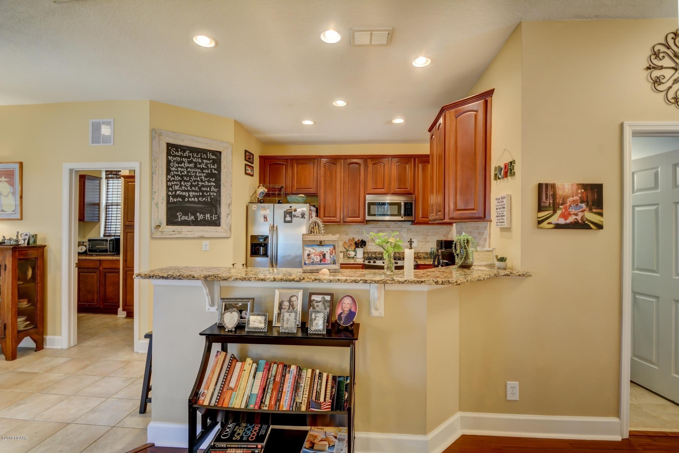 409 Manor View Lane DeLand, FL 32724 - Photo 12 of 31 a kitchen with refrigerator and cabinets