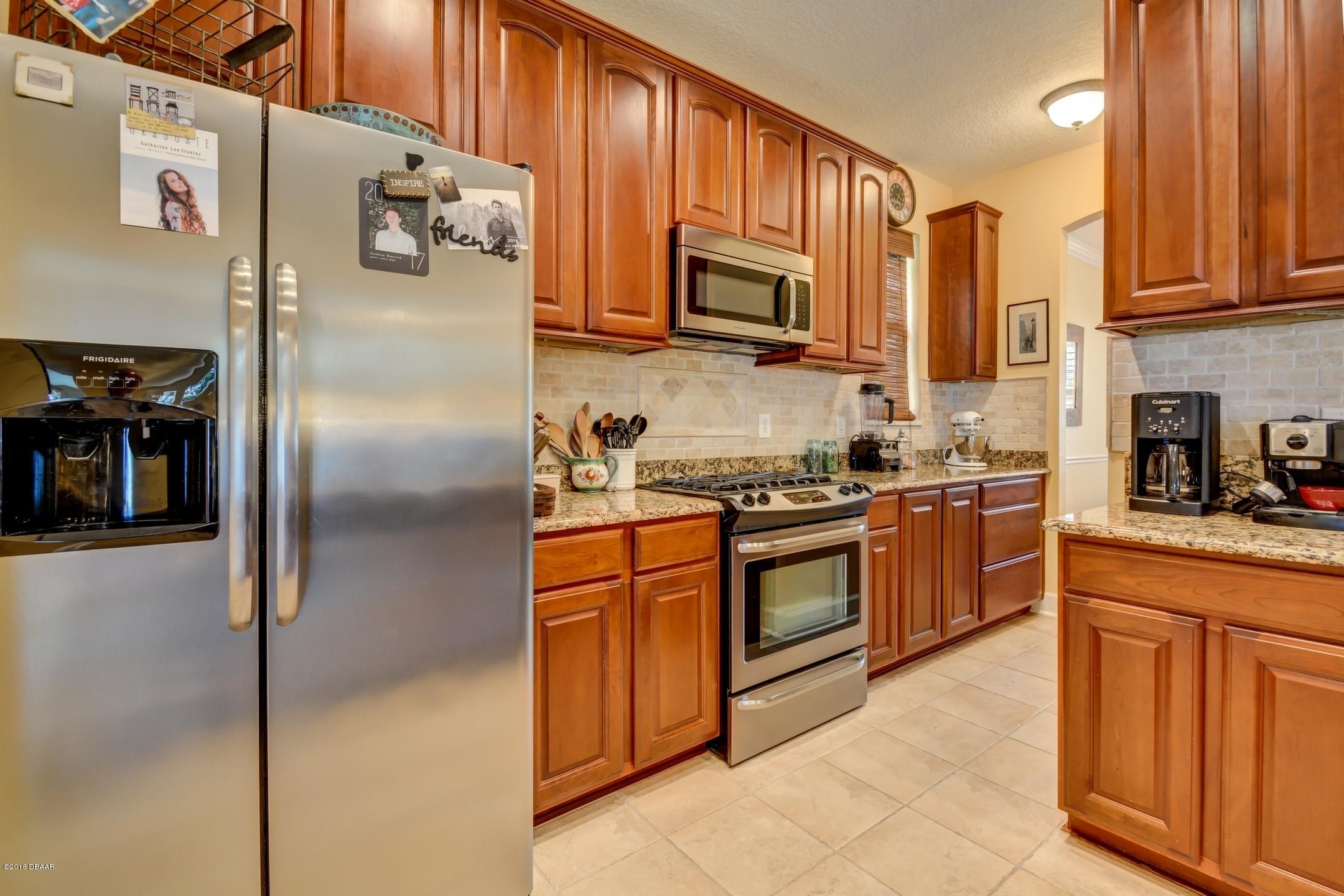 409 Manor View Lane DeLand, FL 32724 - Photo 14 of 31 a kitchen with stainless steel appliances granite countertop a refrigerator a stove top oven a sink and dishwasher