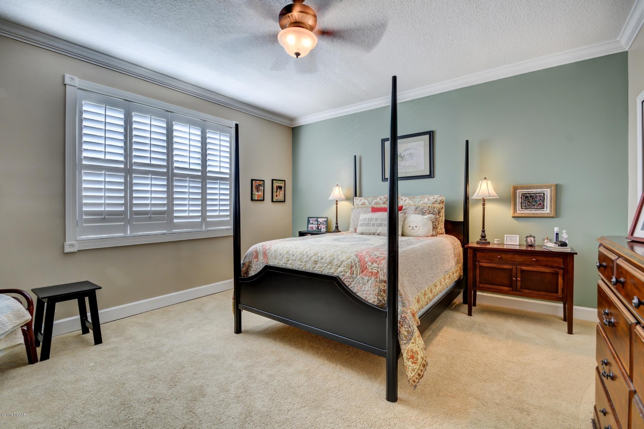 409 Manor View Lane DeLand, FL 32724 - Photo 18 of 31 a bedroom with a bed lamps and a desk