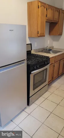 a white refrigerator freezer and a stove sitting inside of a kitchen