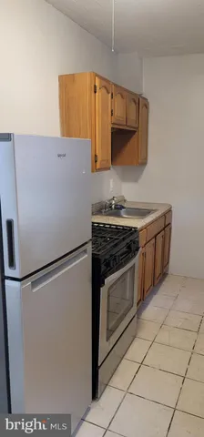 a white refrigerator freezer and a stove sitting inside of a kitchen