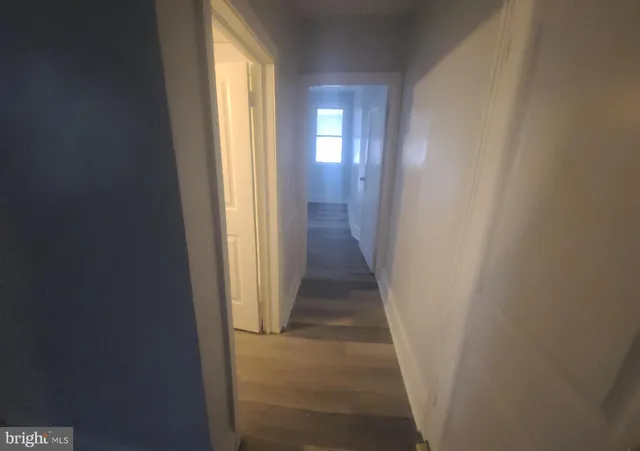 a view of a hallway with wooden floor and windows