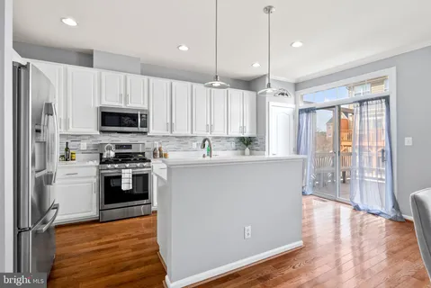 a kitchen with stainless steel appliances sink stove top oven and cabinets