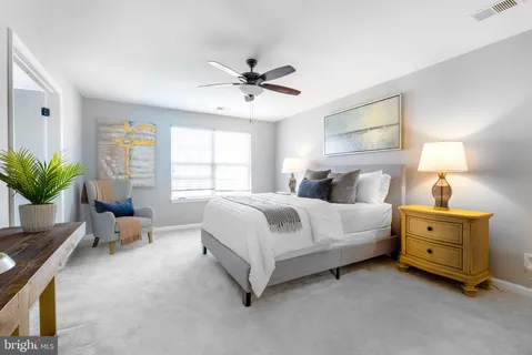 a spacious bedroom with a bed and ceiling fan