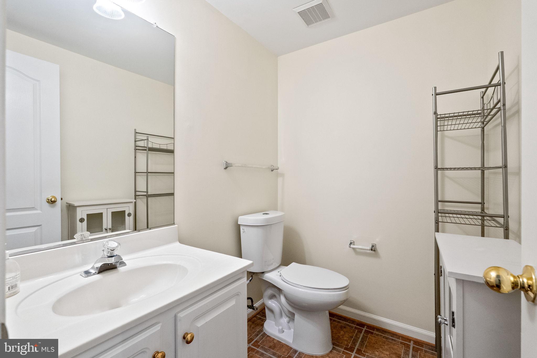 13368 Ferry Landing Lane Woodbridge, VA 22191 - Photo 34 of 44 a bathroom with a sink mirror vanity and toilet